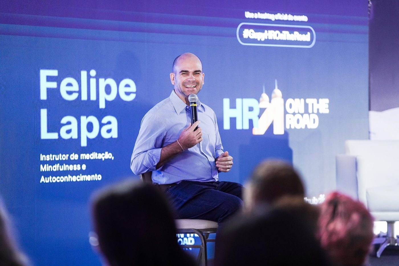 Felipe Lapa no palco, diante de um auditório