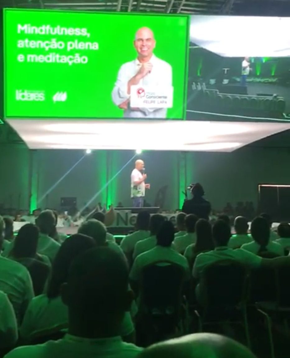 Felipe Lapa no palco da Convenção de Líderes da Neoenergia, em Salvador, com o telão e a plateia